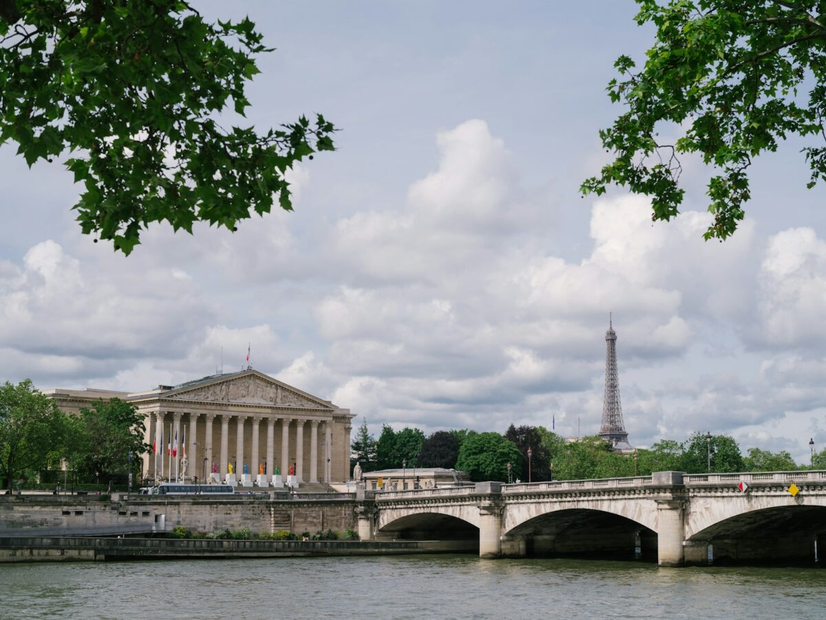 a bridge over a body of water with a building in the background